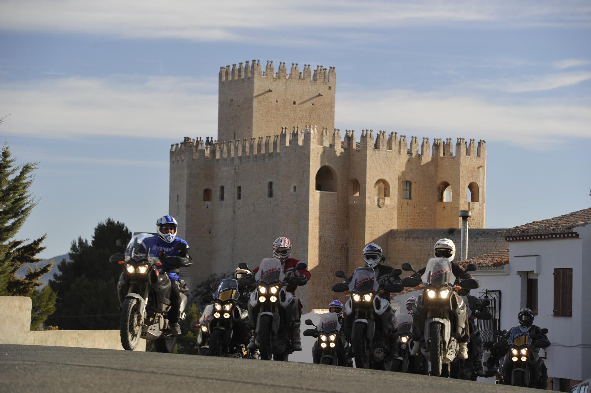 Moto in gruppo con castello sullo sfondo
